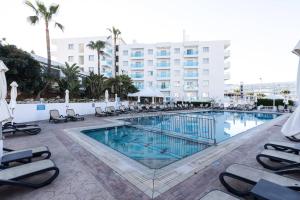 普罗塔拉斯Vrissaki Hotel Apartments的一个带躺椅的大型游泳池和一间酒店