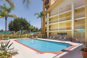 丘拉维斯塔圣地亚哥丘拉维斯塔拉金塔酒店的棕榈树酒店前的游泳池