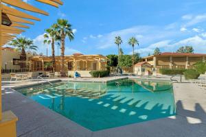 凤凰城凤凰北拉金塔酒店的一座棕榈树游泳池和一座房子