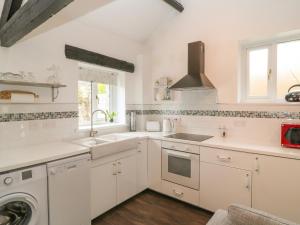 利斯卡德Swift Cottage的白色的厨房配有水槽和洗碗机