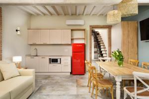 瓦达Antico Podere San Francesco的一间厨房和一间带红色冰箱的客厅