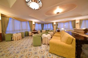 伊斯基亚Grand Hotel Terme di Augusto的酒店客房设有桌椅和等候区。