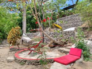 La LagunaCasa Bella的花园设有两把红色椅子和石墙