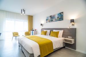 久洛La Vita Prémium Panzió的一间卧室配有一张带黄色毯子的大床