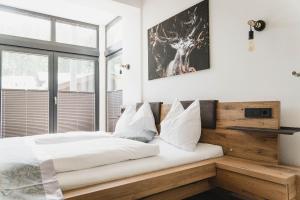 拉肯霍夫MountainLodge am Ötscher的一间卧室配有一张带白色床单的床和一扇窗户。
