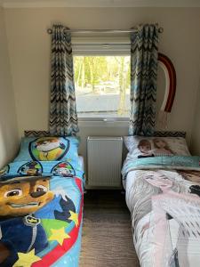 洪德洛Luxe Chalet Hoenderloo Airco, Netflix - Recreation Only的一间卧室设有两张床和窗户。