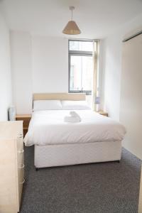 利物浦Serviced Apartment In Liverpool City Centre - Free Parking - Balcony - by Happy Days的卧室设有一张白色大床和一扇窗户。