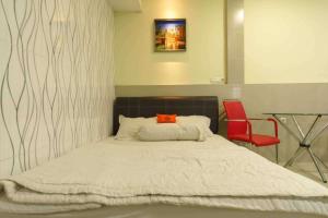 名古屋KoolKost near Nagoya Hill Batam (Minimum Stay 30 Nights)的一间卧室配有一张床和一张红色椅子