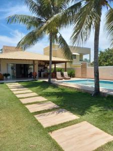 卡马萨里Uma Casa para o Descanso!的棕榈树和游泳池的房子