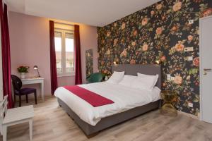维泰勒Hôtel d'Angleterre (by Popinns)的一间卧室配有一张带花卉壁纸的床