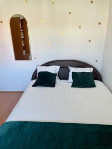 苏提万Apartman Luš的一张带绿色枕头的大白色床