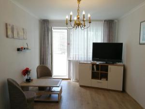 希奥利艾Šiauliai City Apartment的客厅配有平面电视和桌子。