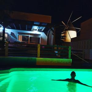 拉斯内格拉斯Casita del Molino的男人在游泳池游泳,晚上带着风车