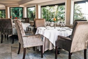 阿曼济姆托蒂精品景观水疗度假酒店的用餐室设有桌椅和窗户。