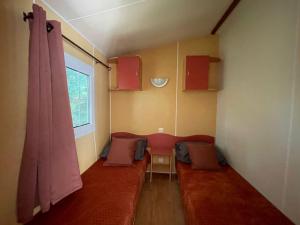 博凯尔Logement 2 chambres avec jacuzzi sur terrain en pleine nature的一间设有红色沙发和窗户的客房