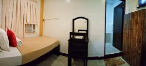宿务宿务艾麦克斯旅馆的一间卧室配有一张带镜子和梳妆台的床
