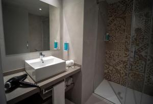 滨海托萨唐璜托萨酒店的一间带水槽、镜子和淋浴的浴室