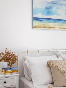 KástronEco Sirma Flaris的卧室配有一张床,墙上挂有绘画作品