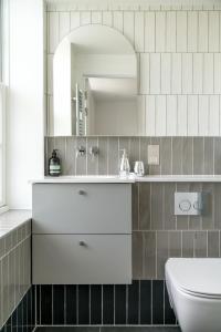 伦敦JOIVY Spectacular 3-bed flat near Holland Park的浴室设有白色水槽和镜子