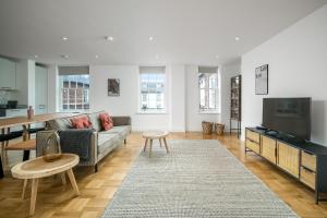 伦敦JOIVY Spectacular 3-bed flat near Holland Park的带沙发和电视的客厅
