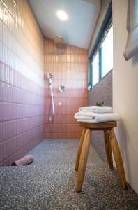 斯普利特Kushin rooms Split的带淋浴的浴室以及带毛巾的桌子。