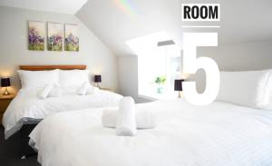 波特里Rooms on the High Street的卧室内的两张床,带有房间标志