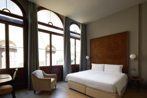 威尼斯戴德格玛尼酒店的一间卧室配有一张床、一把椅子和窗户。