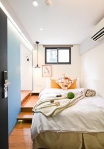 台北在家行旅 中山館的一间卧室配有一张带橙色枕头的大床