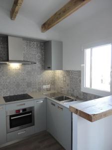 埃斯卡斯特利Sol del Este的厨房配有白色橱柜、水槽和窗户。