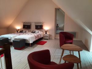 勒布朗Villa du Cerf Thibault的一间卧室配有一张床和两把椅子