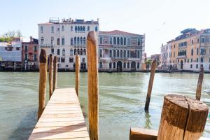 威尼斯戴德格玛尼酒店的建筑物旁边的水面上的木头码头