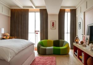 巴黎Sinner Paris的一间卧室配有一张床和一把绿色椅子