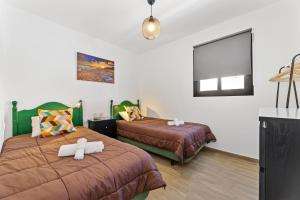 蒂亚斯Holiday in Lanzarote!的一间卧室配有两张床和白色毛巾。