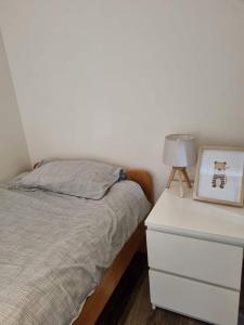 弗尔内Maison Noordburg Veurne的一间卧室配有一张床和一张带照片的梳妆台