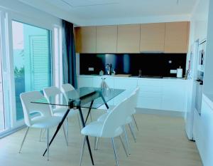 蓬塔德尔加达Consuls Ocean View的厨房配有玻璃桌和白色椅子