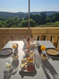 萨尔拉拉卡内达La Maison Thimadaise的一张带食物和饮料的白色桌子