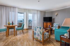 丰沙尔Pestana Grand Ocean Resort Hotel的客厅配有沙发和桌椅