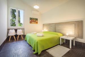 加尔达Villa Brancolin的一间卧室配有绿色的床和两把椅子