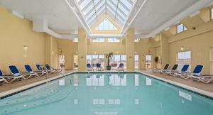 大洋城博尼塔海滩酒店的一个带椅子和天窗的大型游泳池