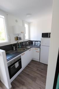 格雷乌莱班Studio tout confort - Climatisation, parking, wifi的白色的厨房配有水槽和冰箱