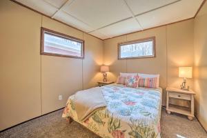 Cozy Petoskey Area Retreat on Burt Lake Access!的一间小卧室,配有床和2个窗户