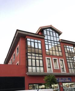 利亚内斯Apartamentos Verdemar (VUT)的大型红色建筑,设有大窗户