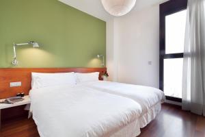 巴塞罗那梅尔卡特巴塞罗那市内公寓的卧室设有一张白色大床和一扇窗户。