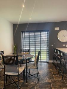 巴拉哈德林5 Ardaun Monasteraden County Sligo的一间带桌椅和时钟的用餐室
