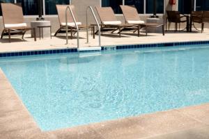 里士满里士满树木园凯悦嘉轩酒店的酒店的大型游泳池配有桌椅