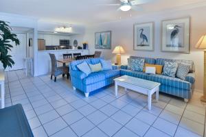 萨尼贝尔COQUINA 3C的客厅配有蓝色的沙发和桌子