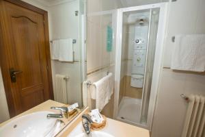 萨拉曼卡雷耶斯卡托里克斯酒店的白色的浴室设有水槽和淋浴。