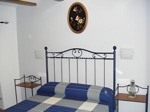 赫里卡Casa rural Teresa la Cuca的一间卧室配有一张蓝色的床和墙上的时钟