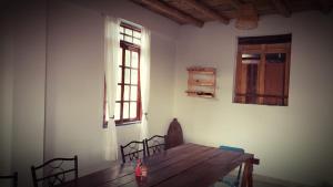 卢那欢纳Lunahuaná CASA DE CAMPO PAULLU的一间带木桌和窗户的用餐室