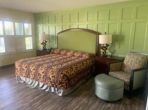 塔瓦雷斯佛罗里达绿地旅馆的一间卧室配有一张大床和一把椅子